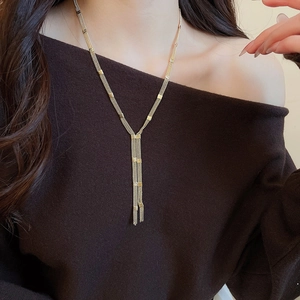 Detail view of multi-layer gold fringe necklace with square accents on a model