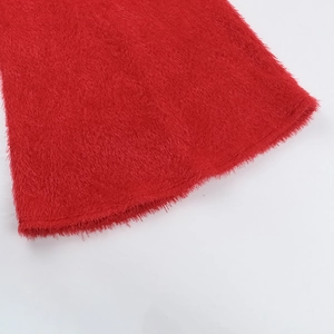Macro shot showing the texture of long red faux fur and fabric detail on the dress hem