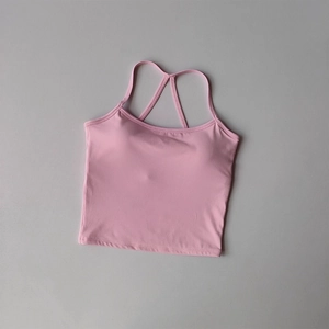 Détail du haut de yoga rose clair avec fines bretelles croisées et tissu élastique doux