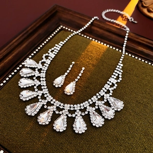 Luxurious silver water drop rhinestone necklace and earring set on green velvet
