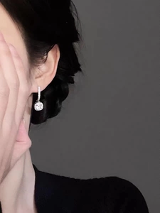 Close-up of square cut crystal drop earrings in sterling silver worn by a model