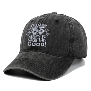 Detail of embroidered 'It Took 65 Years To Look This Good' text on a charcoal baseball cap