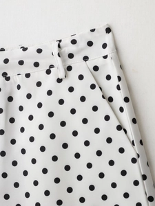 Gros plan d'un ensemble à pois blancs montrant les détails de la taille et des coutures