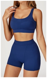 Vista frontale di reggiseno sportivo blu scuro e pantaloncini a vita alta sul modello