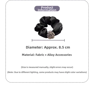 Detail of 8.5cm black satin scrunchie featuring a silver camellia flower alloy charm