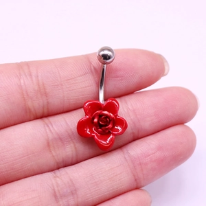 Vue détaillée d'un piercing de nombril rose rouge sur les doigts pour la taille