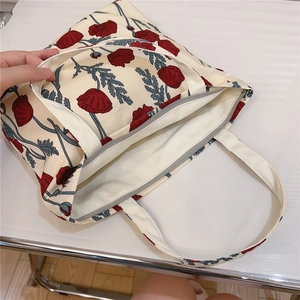 Detail showing the secure zipper closure and durable cotton lining of the floral canvas bag