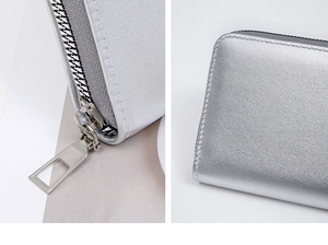 Detail of silver metallic textured wallet showing premium zipper and fine stitching craftsmanship