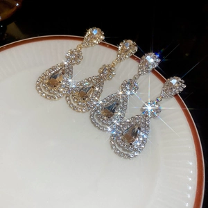 Detail of elegant water drop tassel earrings with rhinestones in gold and silver plating
