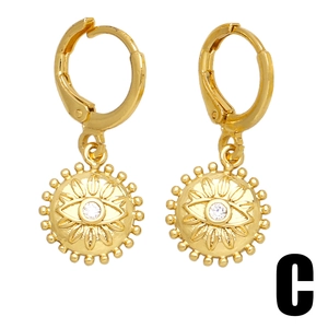 Retro gold celestial hoop earrings featuring crystal starburst sun and evil eye charms
