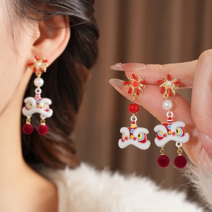 Detail of lion dance earrings with red tassels and pearls for a traditional festive style