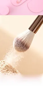Macro shot of high-density powder brush with rose gold ferrule catching fine makeup powder