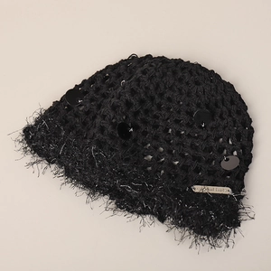 Détail du bonnet noir à paillettes avec plaque en métal argenté et bord à franges