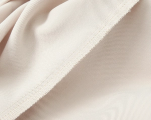 Dettaglio ravvicinato del tessuto del blazer bianco crema e cuciture di precisione