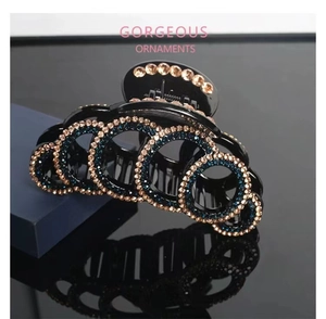 Detail of luxury hair claw clip featuring champagne and blue crystals in a circular pattern