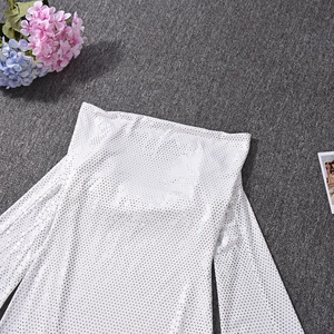 Gros plan du tissu blanc à pois pailletés avec manches longues évasées et ajours