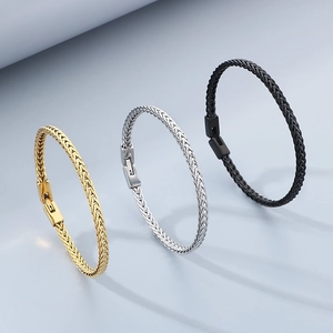 Drei Drachenknochen-Armbänder in Gold Silber und Schwarz auf grauem Hintergrund