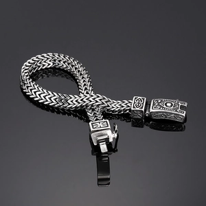 Detailed shot of retro silver woven wheat chain bracelet with an embossed Nordic clasp