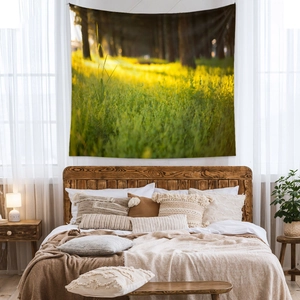 Bohemian forest landscape tapestry hanging over a bed in a bright modern bedroom