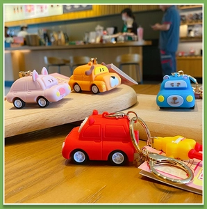 Macro detail of cartoon animal car charms in pink, orange, blue, and red with gold rings