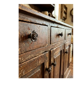Close-up of vintage cast iron rose drawer knob with an antique bronze finish on wood