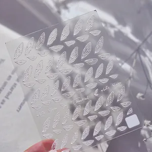 Dettaglio macro degli adesivi per unghie 3D Tomoni white wings con texture a rilievo