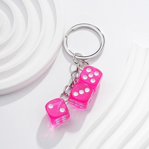 Detailed view of pink transparent dice keychain with metal ring on white background