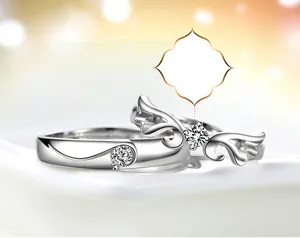 Close-up of silver angel wing wedding bands featuring heart design and sparkling diamonds