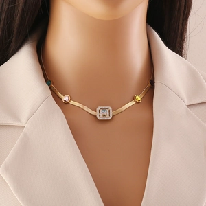 Collier chaîne serpent dorée avec pendentif zircon carré coloré sur un mannequin