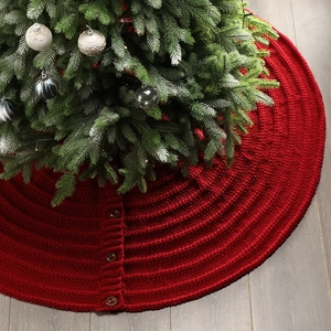 Detail of red cable knit Christmas tree skirt with decorative wooden buttons closure