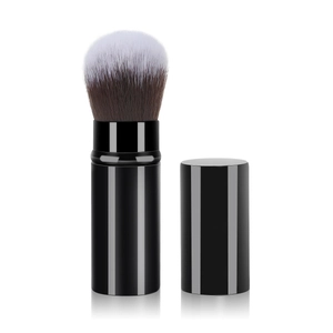 Detail of retractable makeup brush with black glossy handle and dual-tone bristles