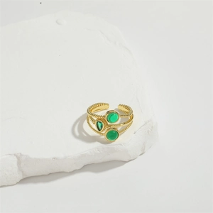Detail of 14K gold plated layered ring with green cubic zirconia and twisted band