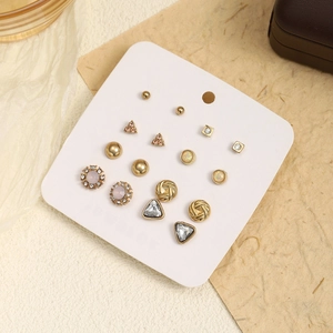 Detail of 9 pairs golden stud earring set featuring rhinestones and various geometric shapes