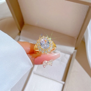 Macro shot of gold floral halo ring with sparkling clear stones in a jewelry box