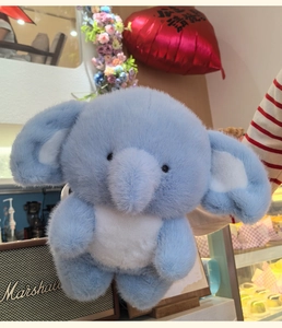 Close-up of the long-fiber faux fur texture on a blue plush elephant doll for kids
