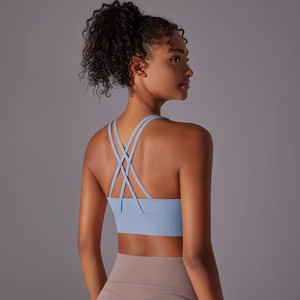 Dettaglio reggiseno sportivo azzurro con spalline incrociate sul retro per lo yoga