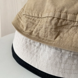 Foldable cotton bucket hats for women in khaki, white, and black with reinforced stitching