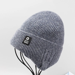Detail of dark grey knit beanie featuring a vertical ribbed texture and brand woven label