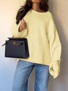 Detail of loose beige knit sweater with long sleeves and round neck style