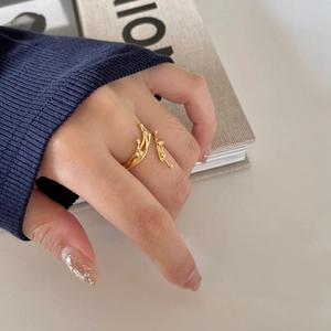 Detailed view of an organic lava-style gold ring on finger with dark navy textured cuff