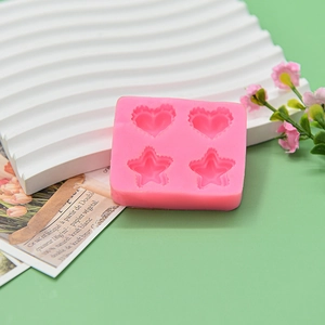 Detail of pink silicone mold featuring four cavities for heart and star shaped DIY crafts