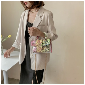 Detail of transparent jelly bag featuring colorful graffiti, gold chain, and metal lock