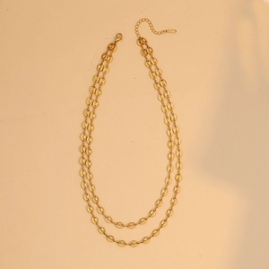 Dettaglio della collana a doppio strato dorata con maglie a naso di maiale e moschettone