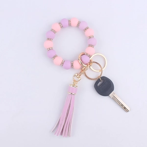 Detail of pink and purple silicone beaded bracelet keychain with rhinestones and tassel