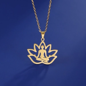 Macro shot of gold stainless steel yoga lotus pendant with meditating silhouette detail