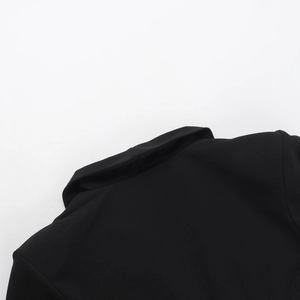 Gros plan du col en V profond et des détails de couture sur une robe blazer noire