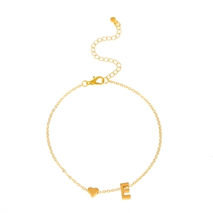 Bracelet doré avec pendentif cœur et lettre E, chaîne ajustable sur fond blanc