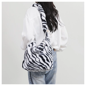 Detail of zebra print faux fur crossbody bag with soft plush texture and wide strap