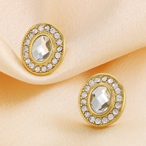 Vue macro des boucles d'oreilles ovales dorées 18K avec grand cristal et détails en zircon