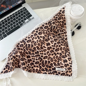 Detail of leopard print cotton triangle headscarf with white lace trim and 100% cotton tag